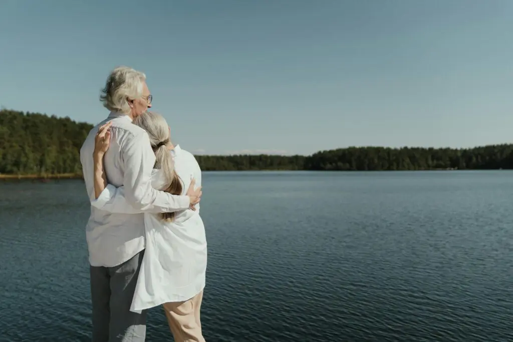 retired couple enjoying their life in front of a big lake