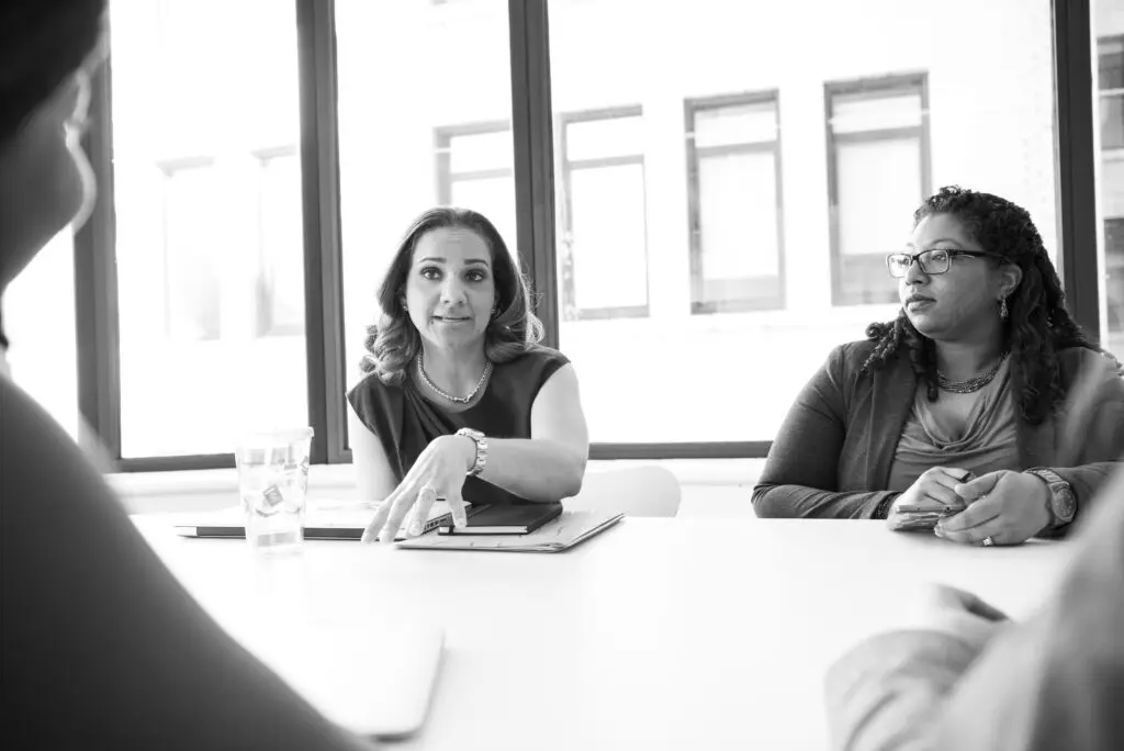 Black and white photo of women meeting in a conference room
