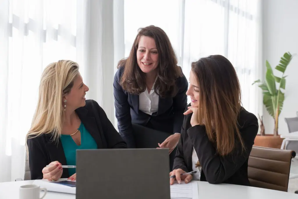 Three women reviewing a financial plan together at a laptop