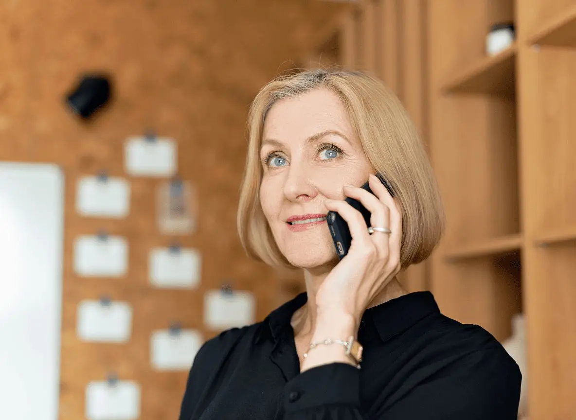 professional woman in a planning meeting reviewing financial documents with her financial advisor on the phone