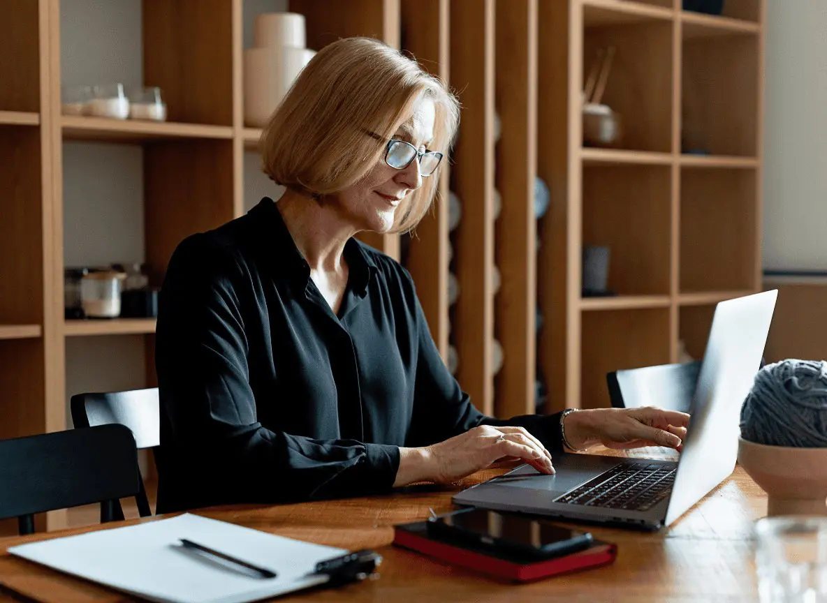 Woman in her fifties reviewing retirement account statements at a desk