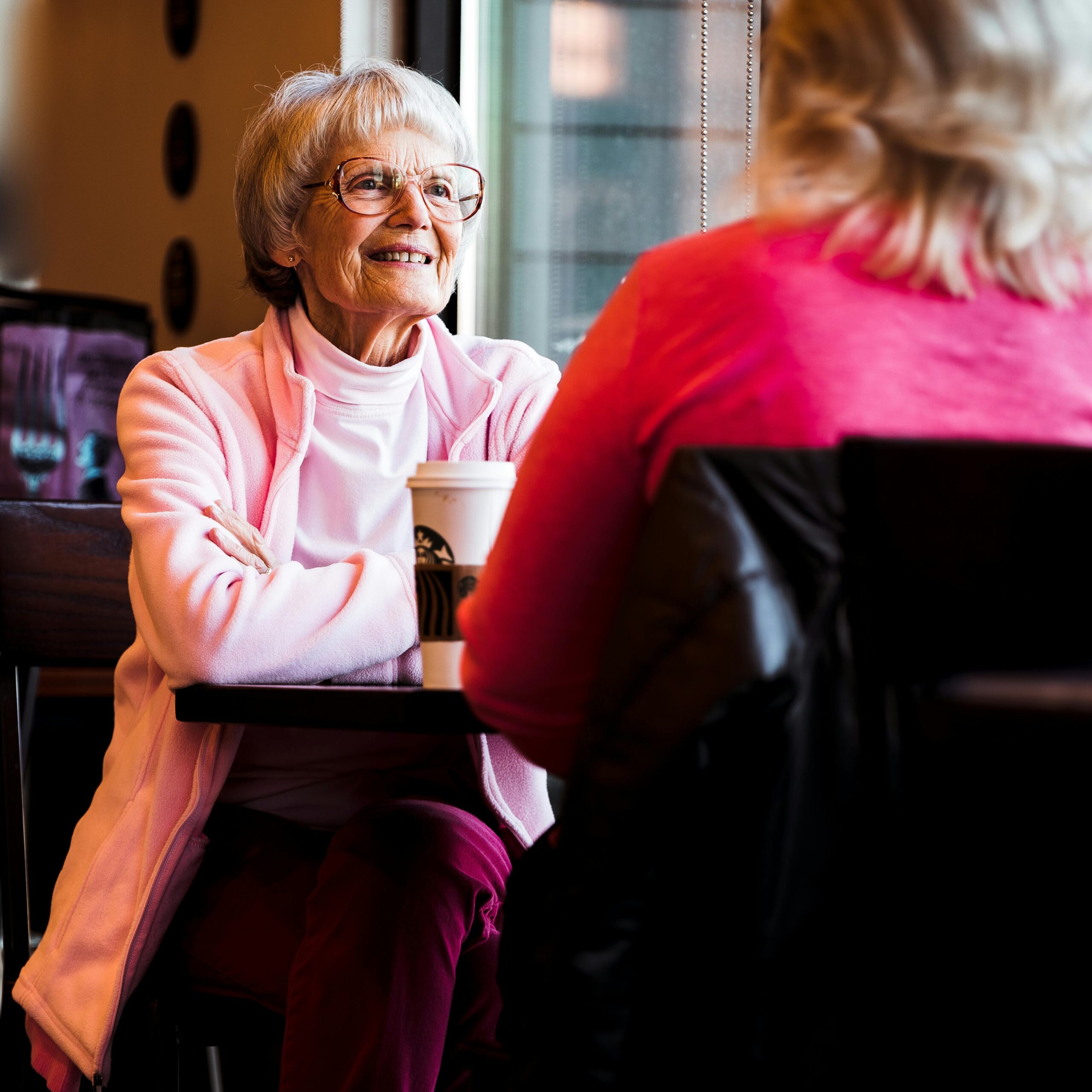 widowed woman in pink talking to her friend