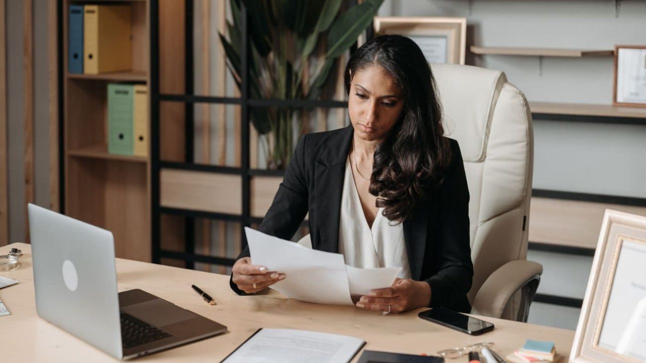 Professional woman reviewing her estate planning documents at an office desk