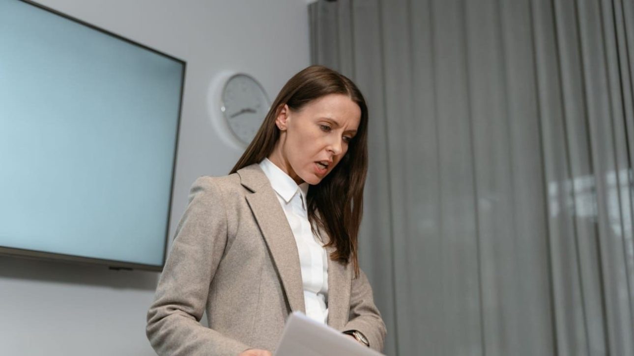 Woman in a blazer reviewing paperwork while deciding whether to keep her financial advisor after divorce