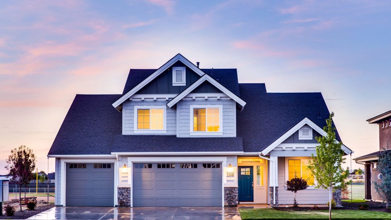 A well kept two story family home at dusk, the kind of house a widow must decide whether to sell or keep