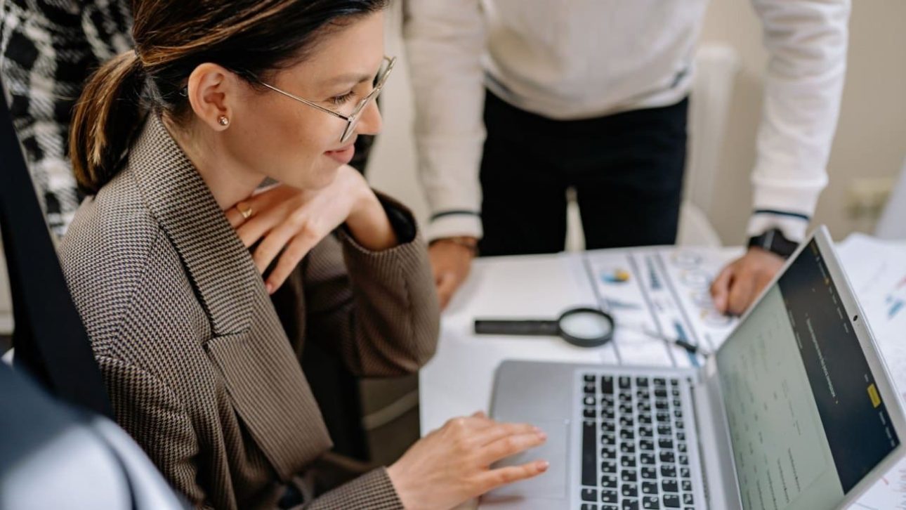Businesswoman at an office desk reviewing her Johnson and Johnson employee benefits on a laptop