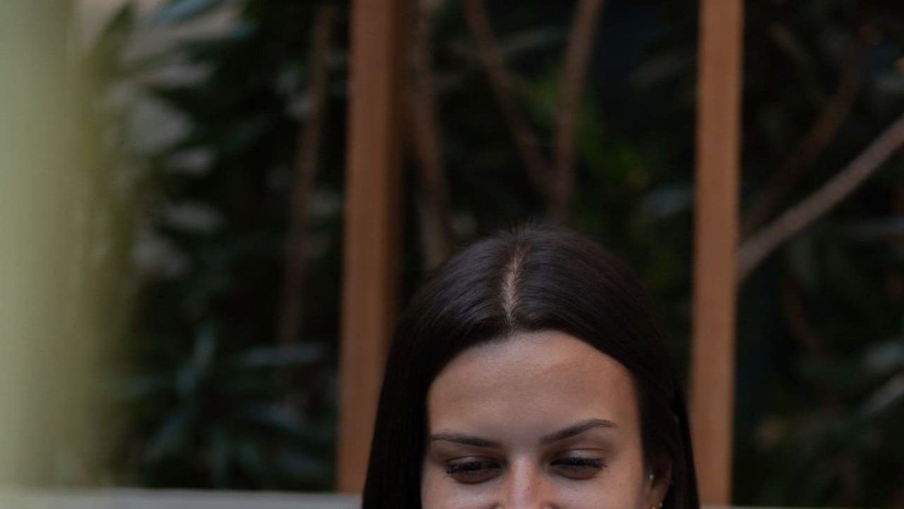 Smiling professional woman working on a laptop, reviewing her LinkedIn employee benefits