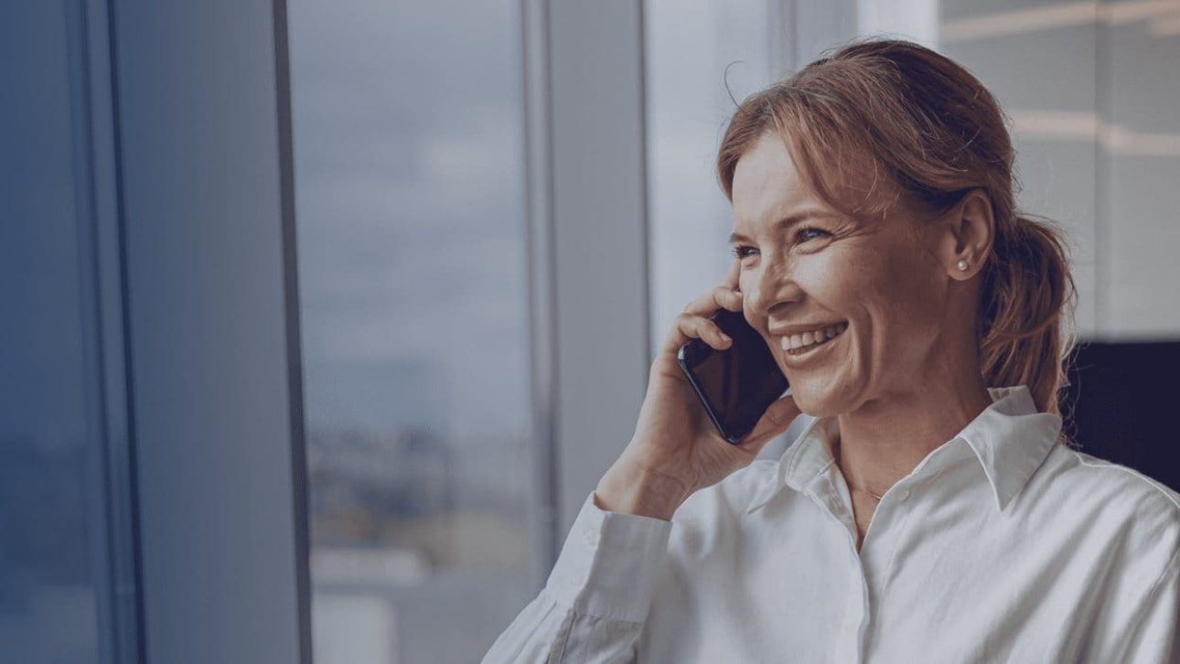 woman is answering the phone by the window