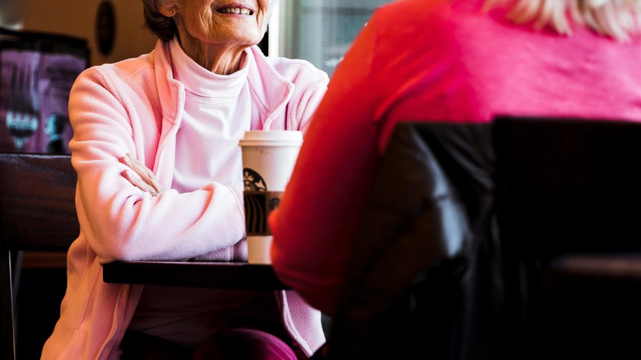 widowed woman in pink talking to her friend