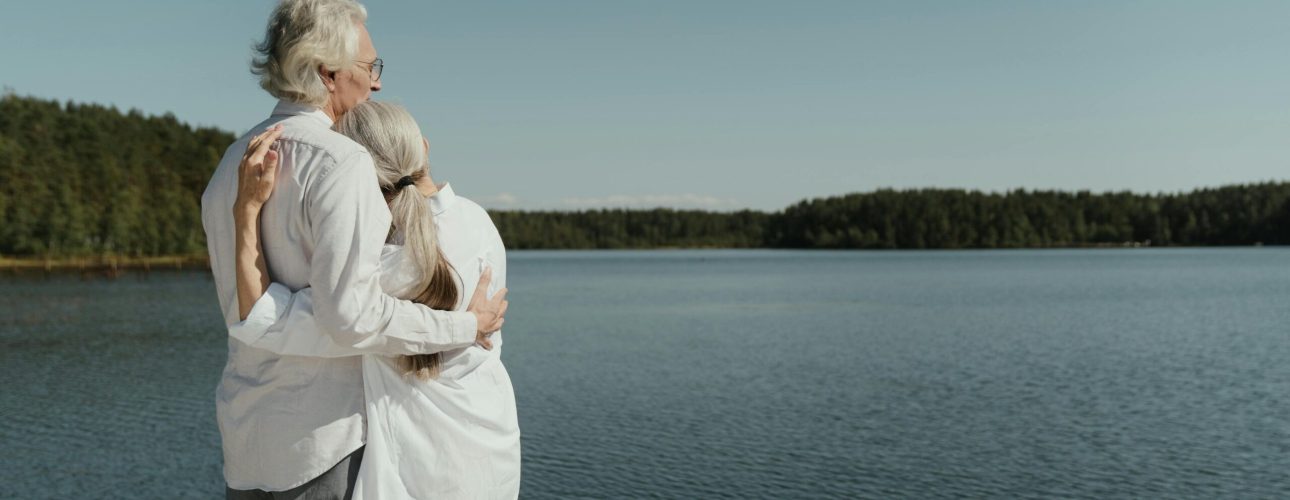 retired couple enjoying their life in front of a big lake