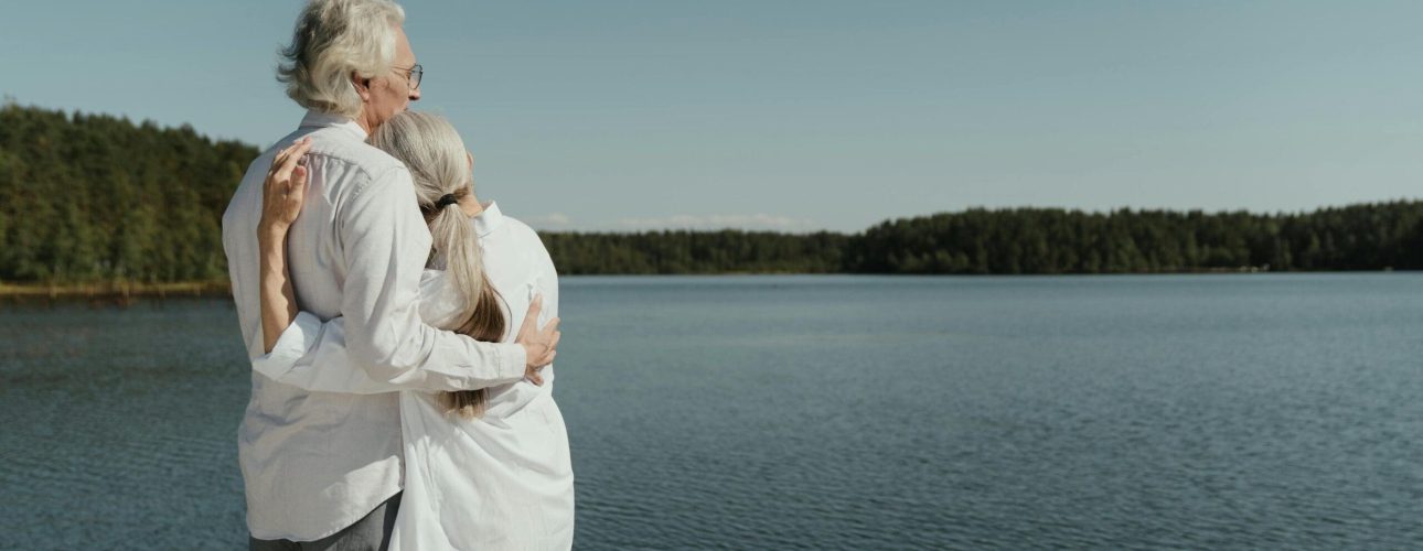retired couple enjoying their life in front of a big lake