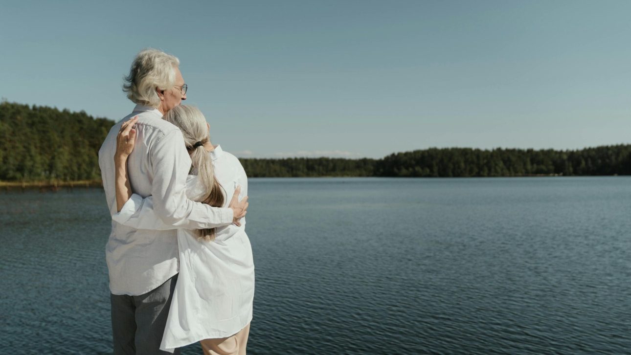 retired couple enjoying their life in front of a big lake