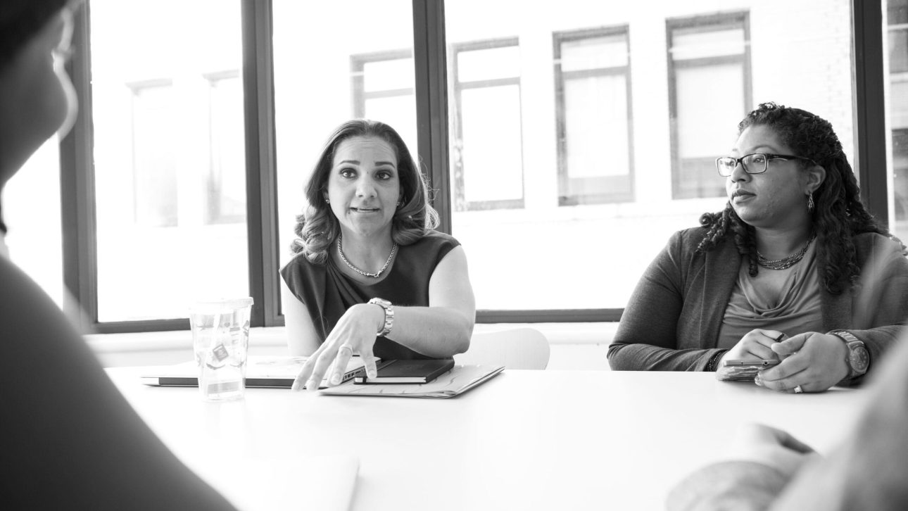 Black and white photo of women meeting in a conference room