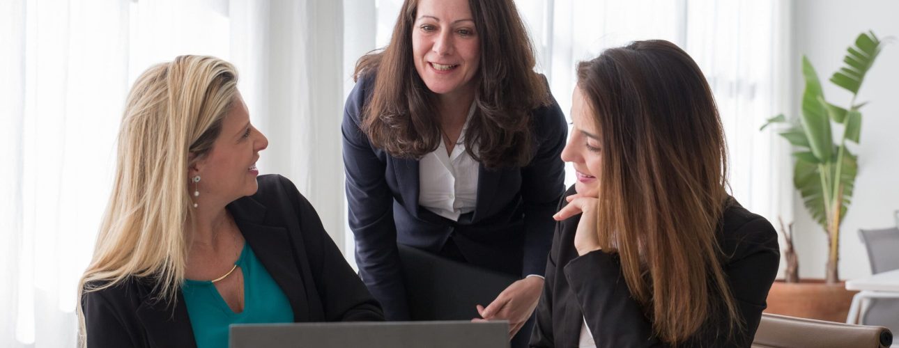 Three women reviewing a financial plan together at a laptop